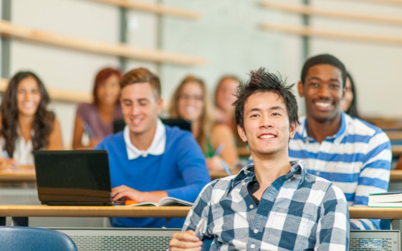 大学の講義室で授業を受ける多国籍の学生たち